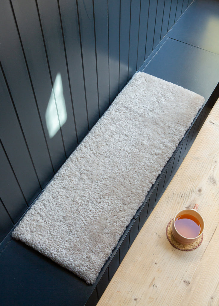 Natural short hair sheepskin bench pad in oatmeal with foam cushioning and non-slip microfibre base