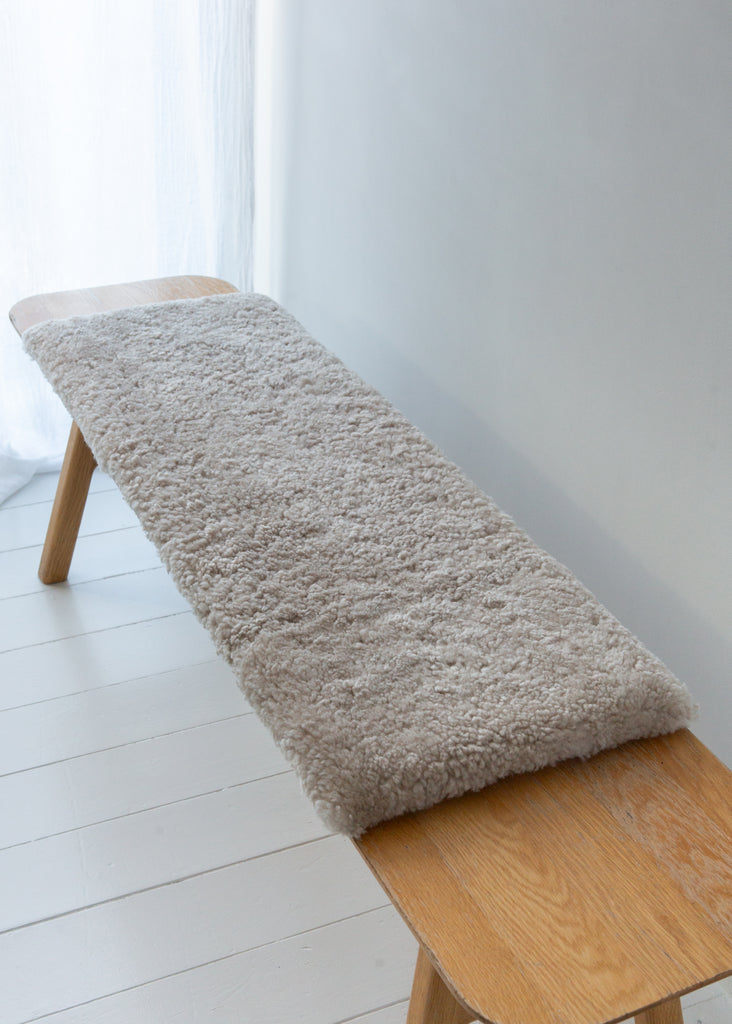 Natural short hair sheepskin bench pad in oatmeal with foam cushioning and non-slip microfibre base