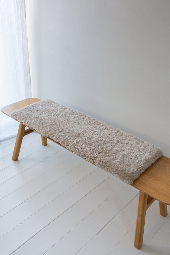 Natural short hair sheepskin bench pad in oatmeal with foam cushioning and non-slip microfibre base