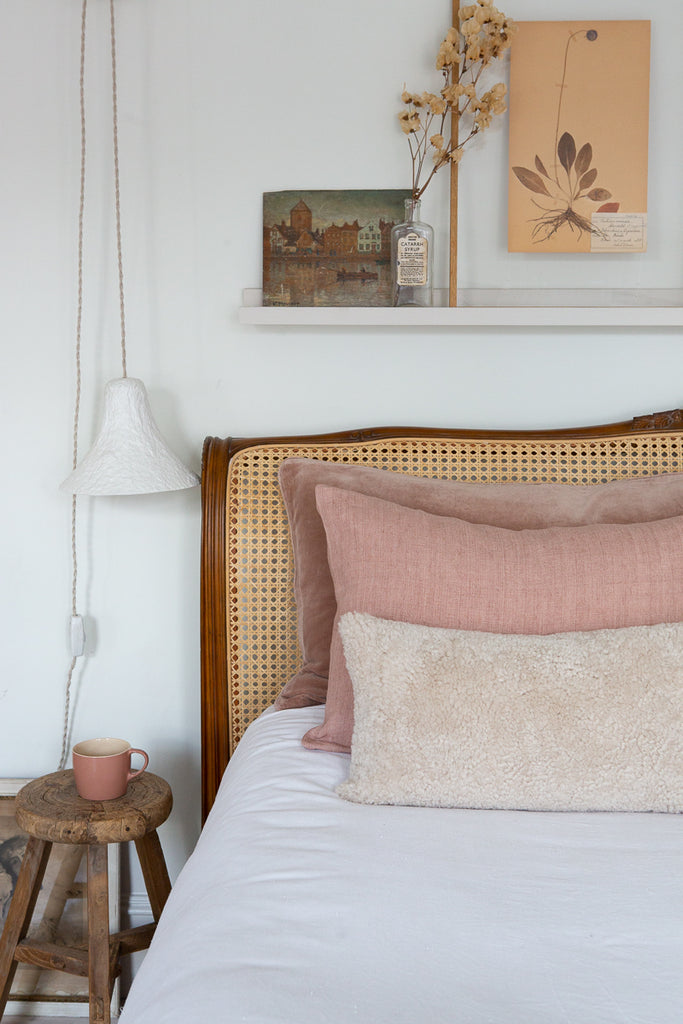 Sheepskin cushion styled on bed