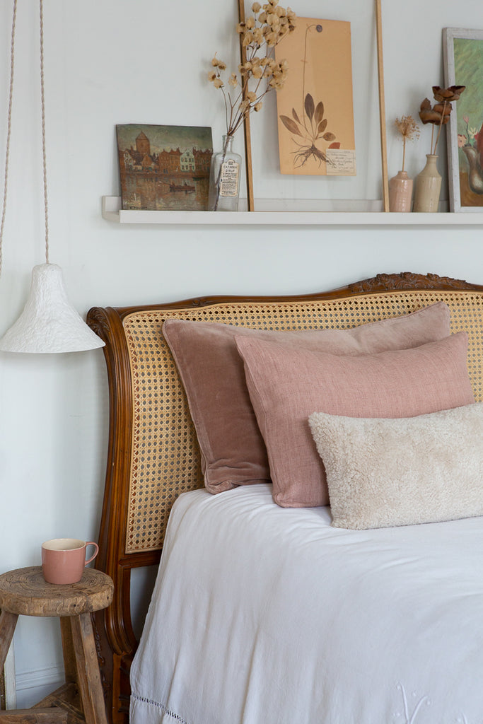 Sheepskin cushion styled on bed