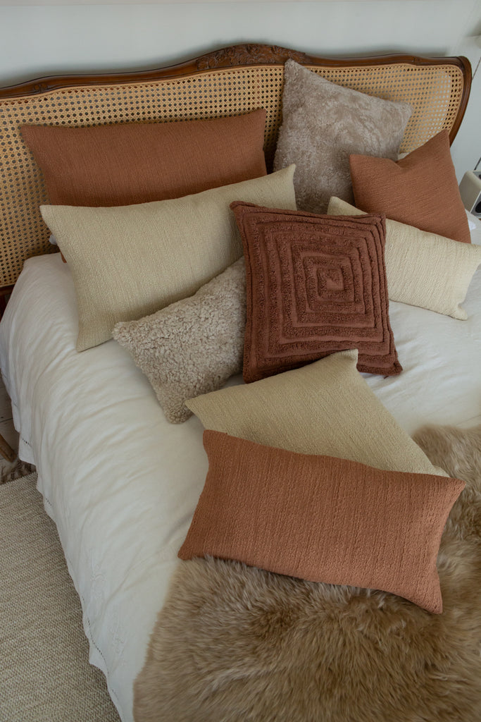 Small rectangular cushion in clay pink slubby cotton and Spiral tufted cushion in mocha linen