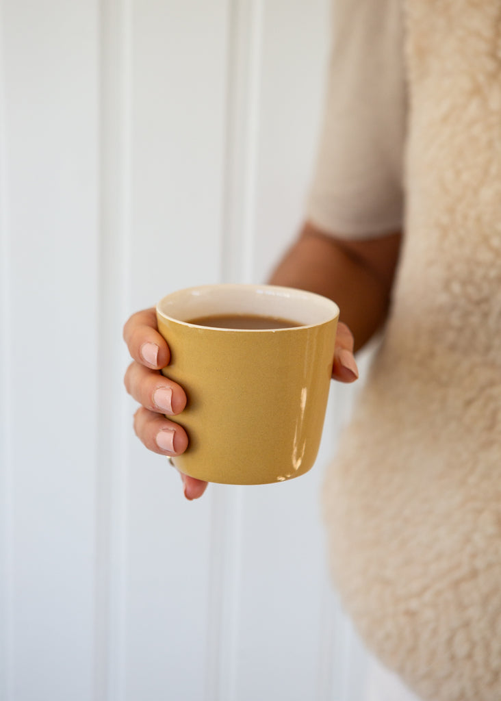 yellow Brickett Davda coffee cup