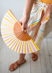 Person holding a colorful striped fan with a light background