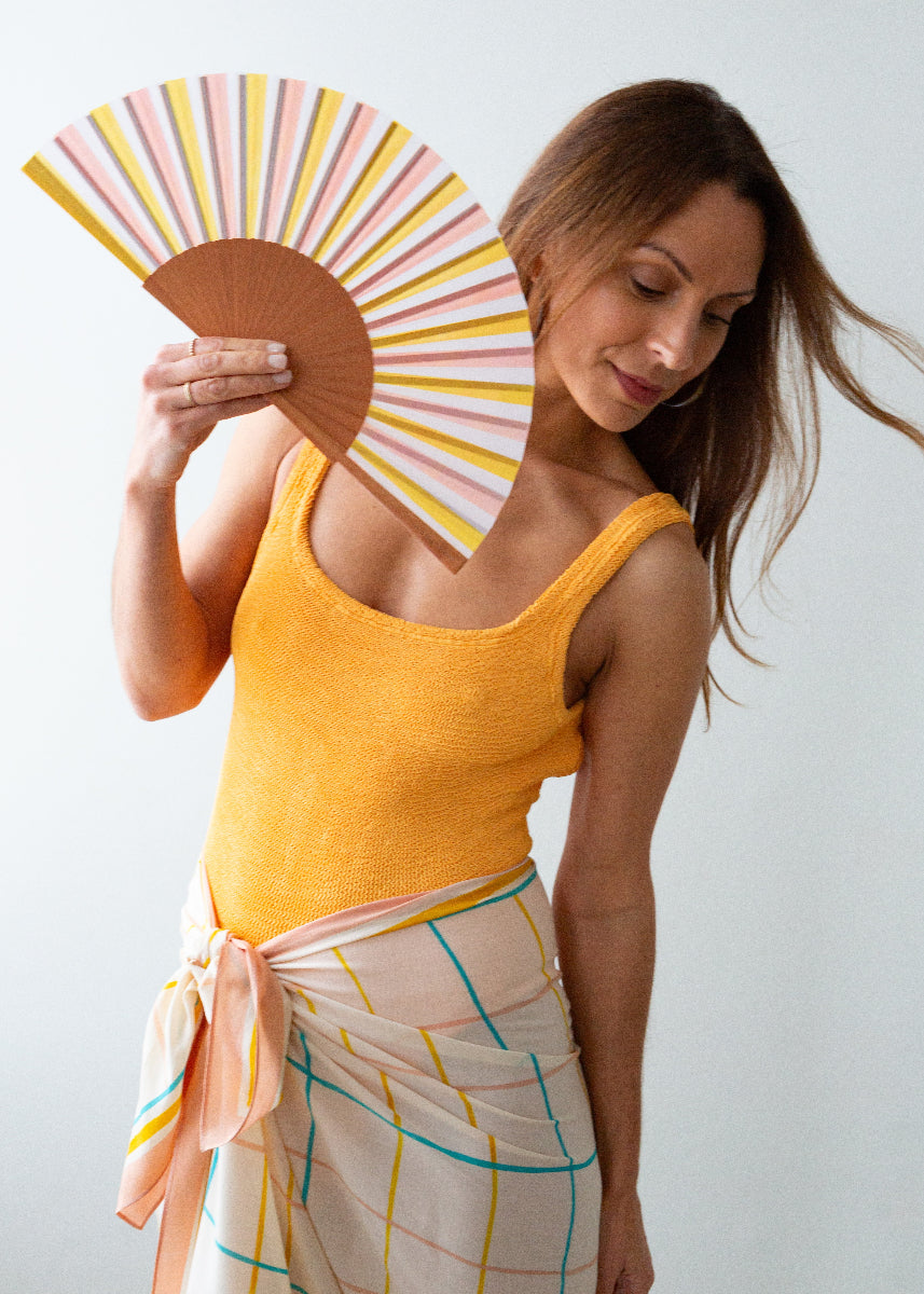 Woman holding a colorful fan against a white background