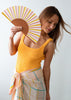 Woman holding a colorful fan against a white background