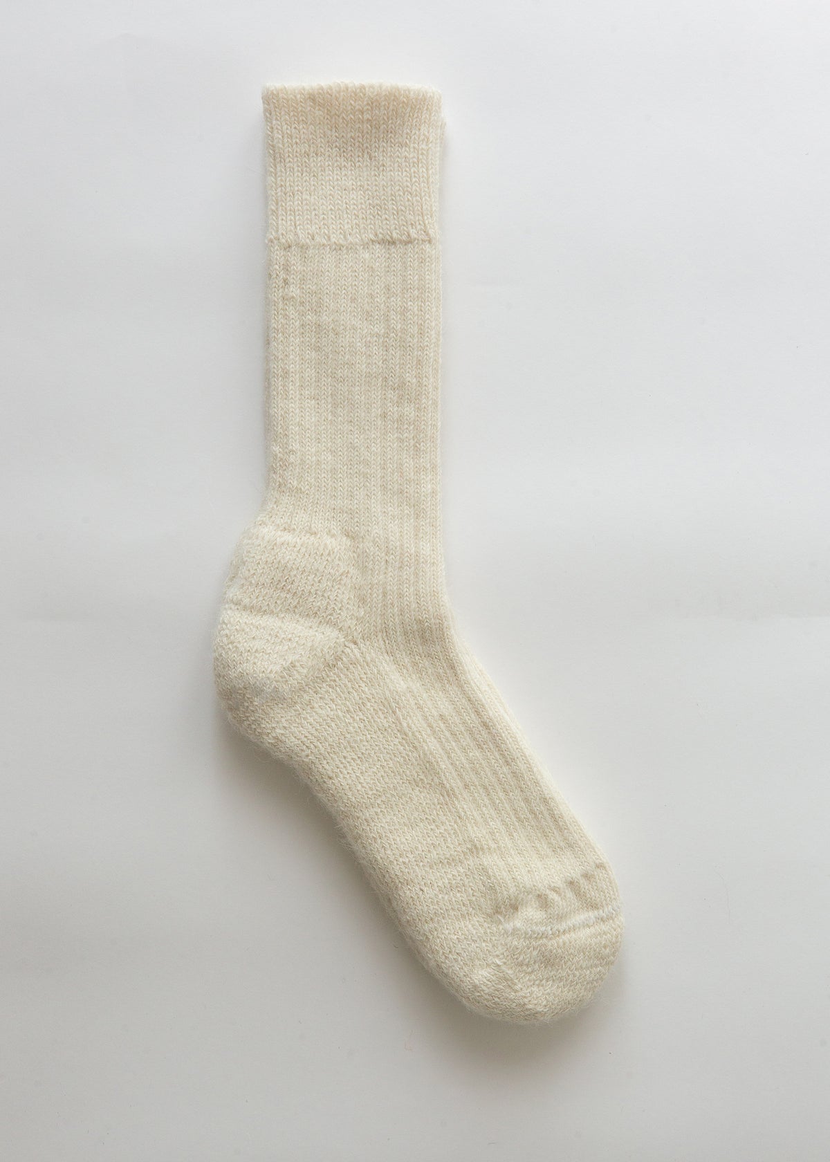 A single cream-colored ribbed knit alpaca sock displayed vertically against a clean, light off-white background.
