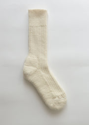 A single cream-colored ribbed knit alpaca sock displayed vertically against a clean, light off-white background.