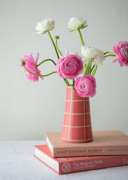 pink vase with grid pattern and flowers