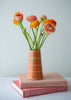 orange handmade vase with grid pattern and orange flowers