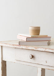 Wooden chair with a cushion next to a small wooden table on a light wooden floor.