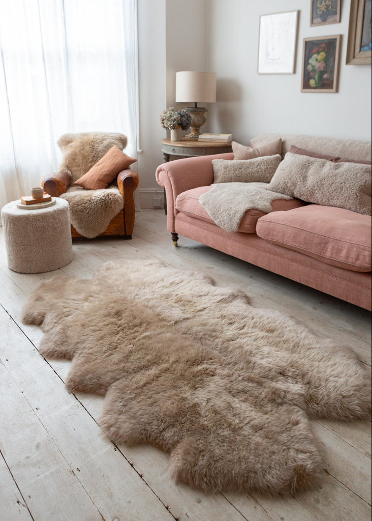 deep pile sheepskin rug on the floor next to a sofe