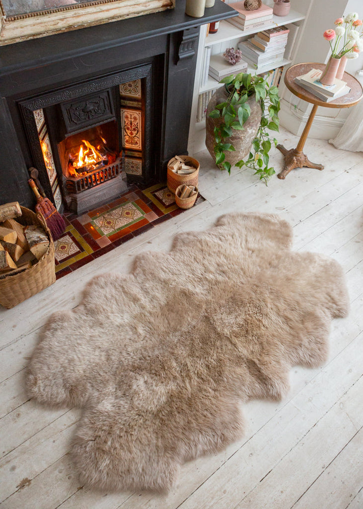 quatro sheepskin rug next to an open fire