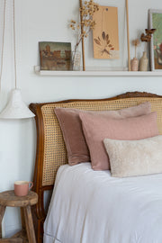 Sheepskin cushion styled on bed