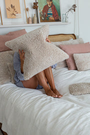 Sheepskin cushion on bed