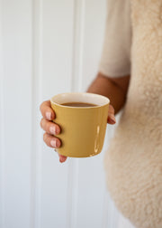 yellow Brickett Davda coffee cup