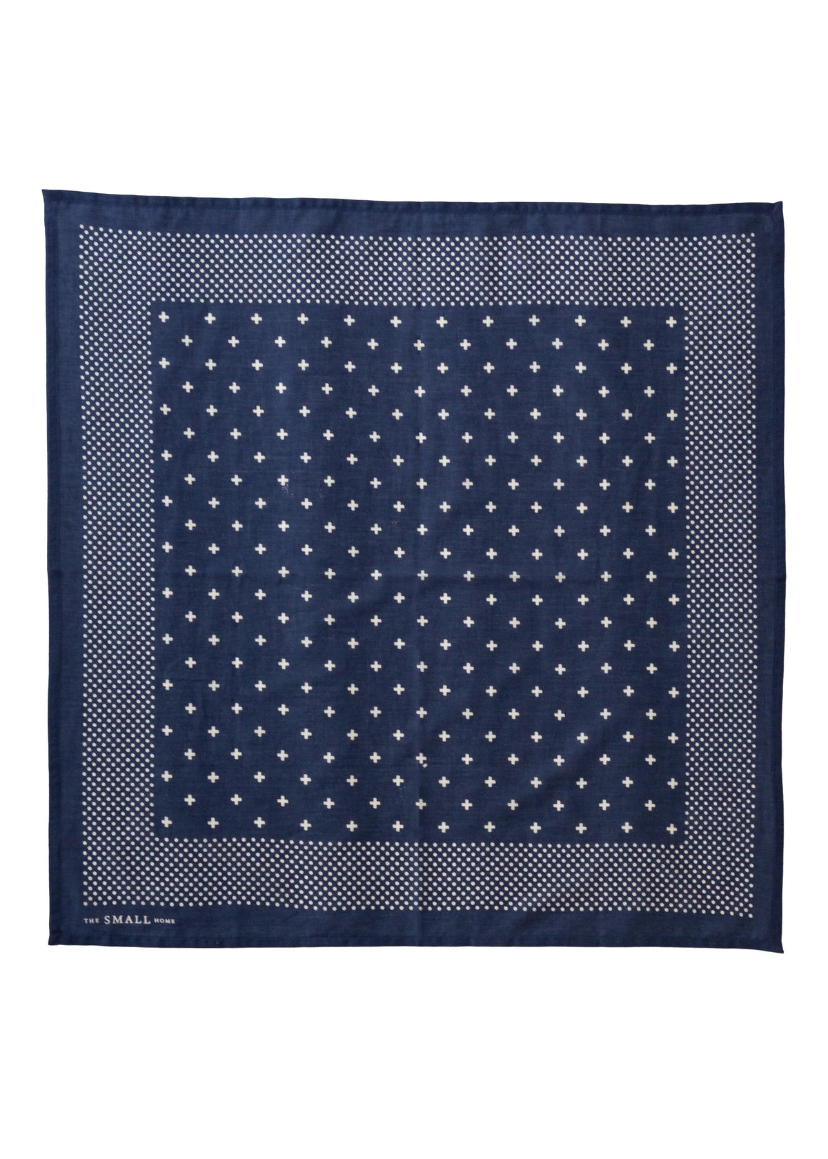 A square navy blue silk scarf with a white geometric pattern, featuring a central field of small white stars and a dotted border, laid flat on a white background.